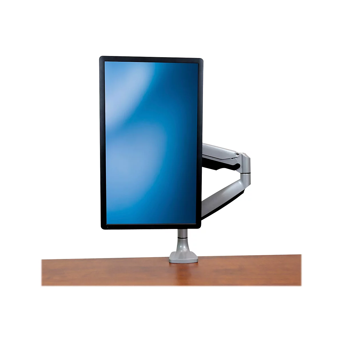 Ein Monitor mit Halterung steht auf einem Holztisch. Der Bildschirm zeigt einen blauen Farbverlauf.