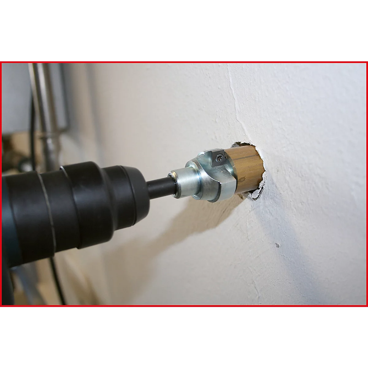 Bohrmaschine bohrt in eine Wand. Bohrer in der Wand, Metallmanschette am Bohrer.