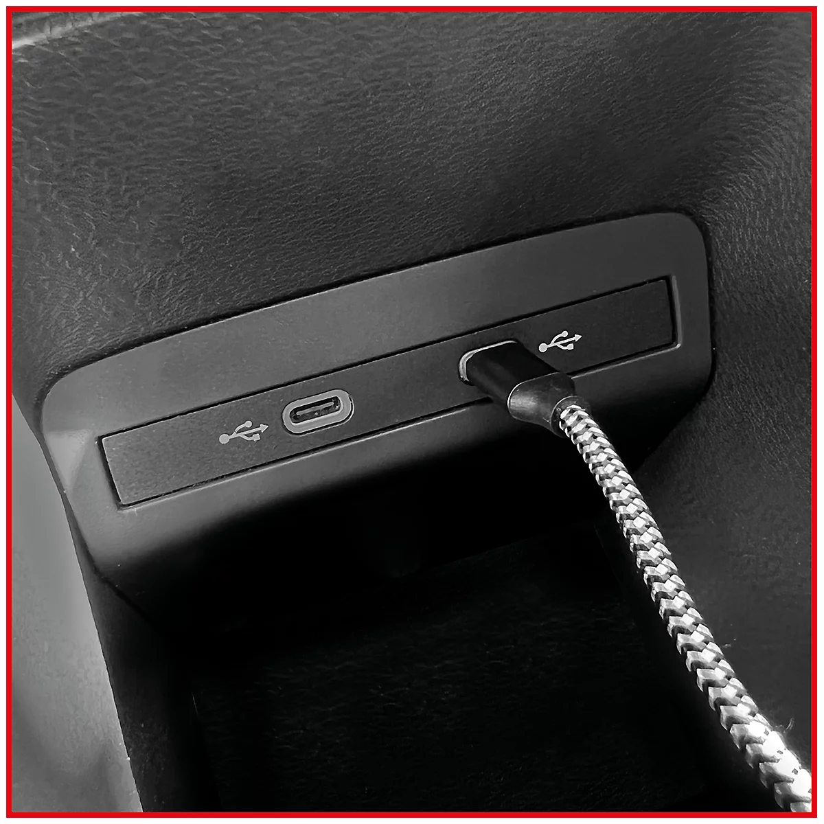 Nahaufnahme einer USB-Buchse im Auto, mit Kabel.