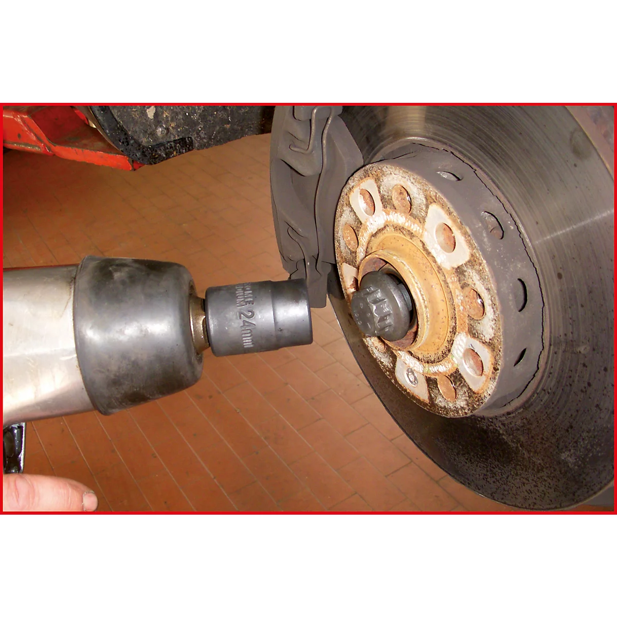 Ein Schraubenschlüssel wird an der Radnabe eines Autos verwendet, um die Radmutter zu lösen.