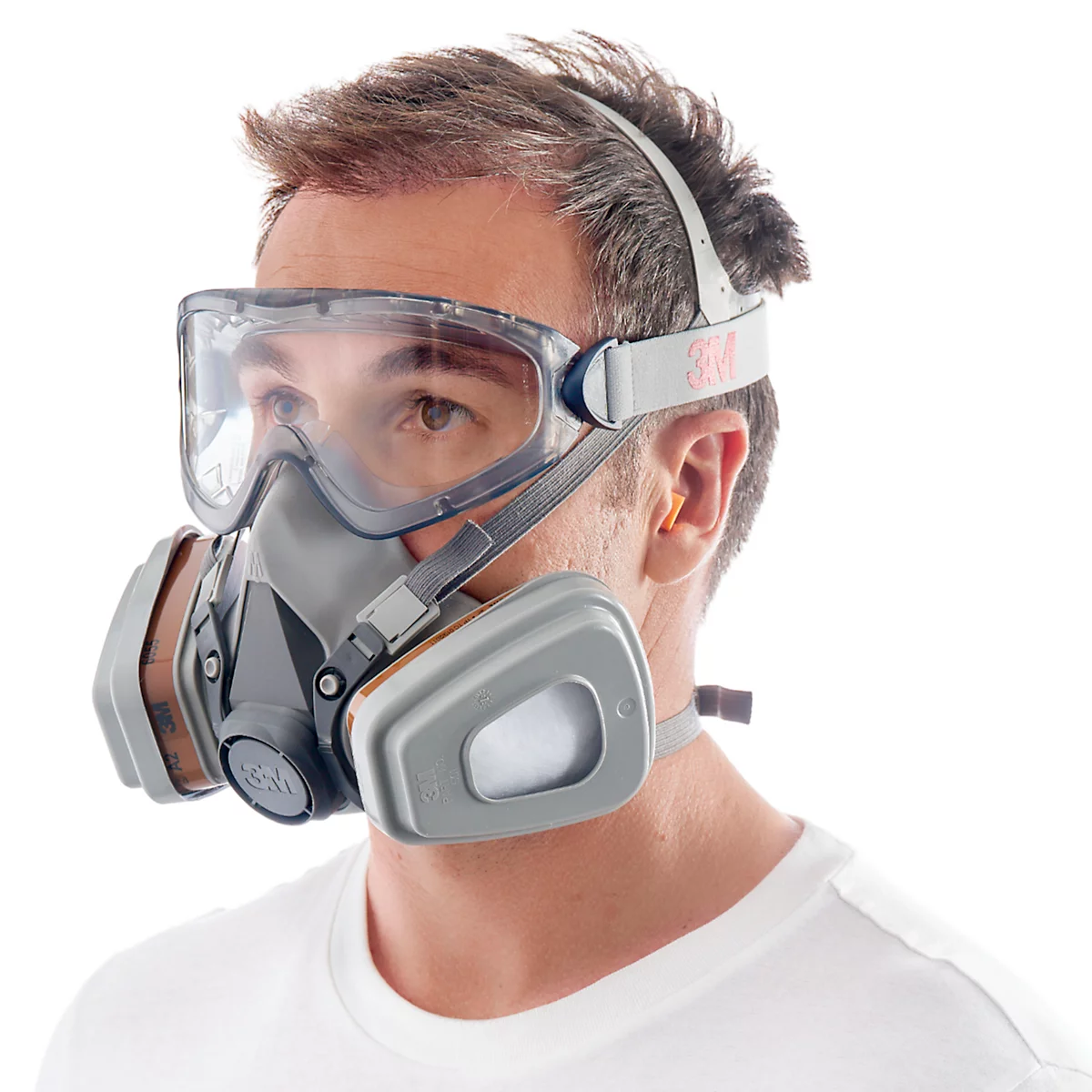 Man met grijs half gelaatsmasker, veiligheidsbril en gehoorbescherming. Wit T-shirt, witte achtergrond.