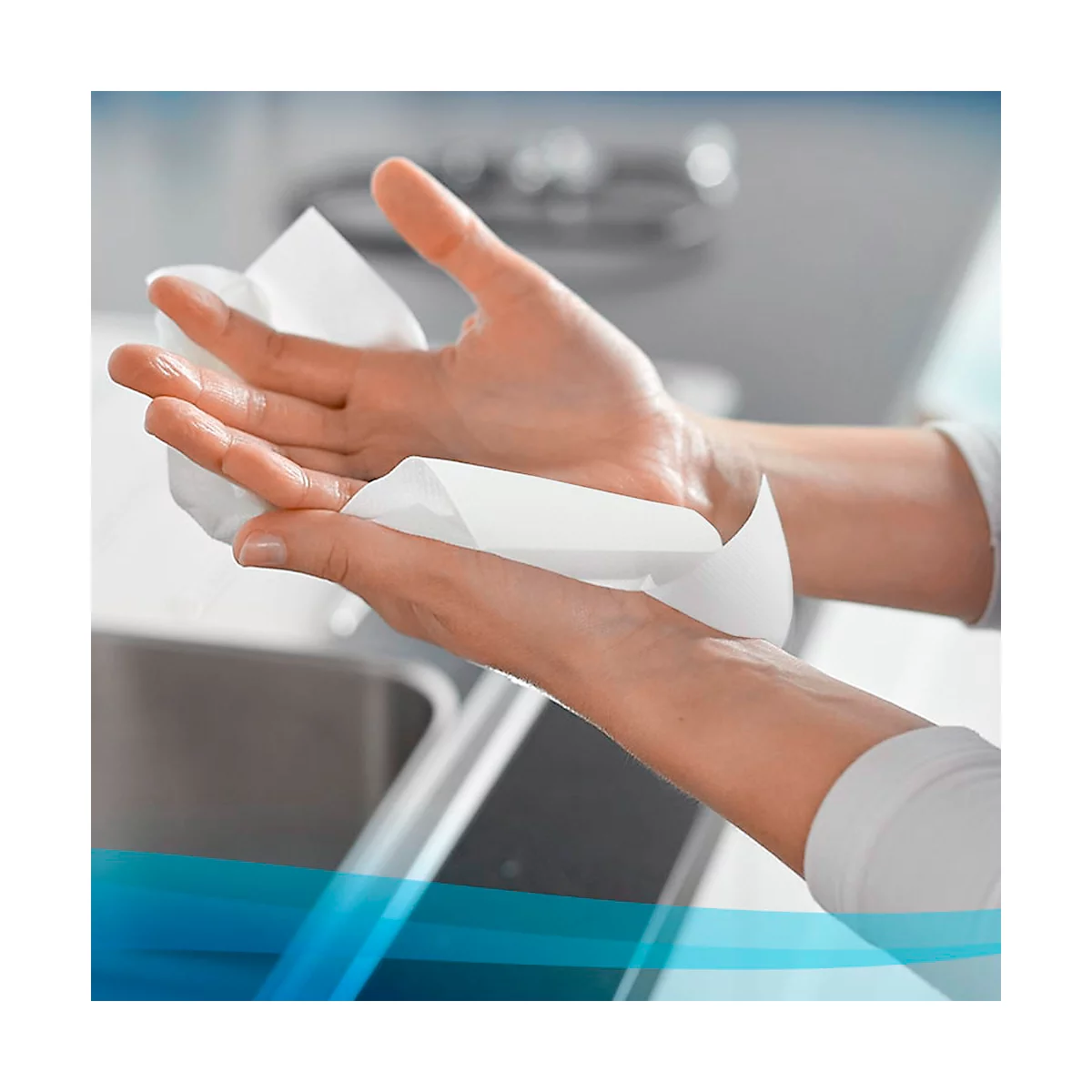 Hände halten ein weißes Tuch, wahrscheinlich ein Reinigungstuch. Der Hintergrund ist unscharf, was auf eine Szene im Innenbereich hindeutet.