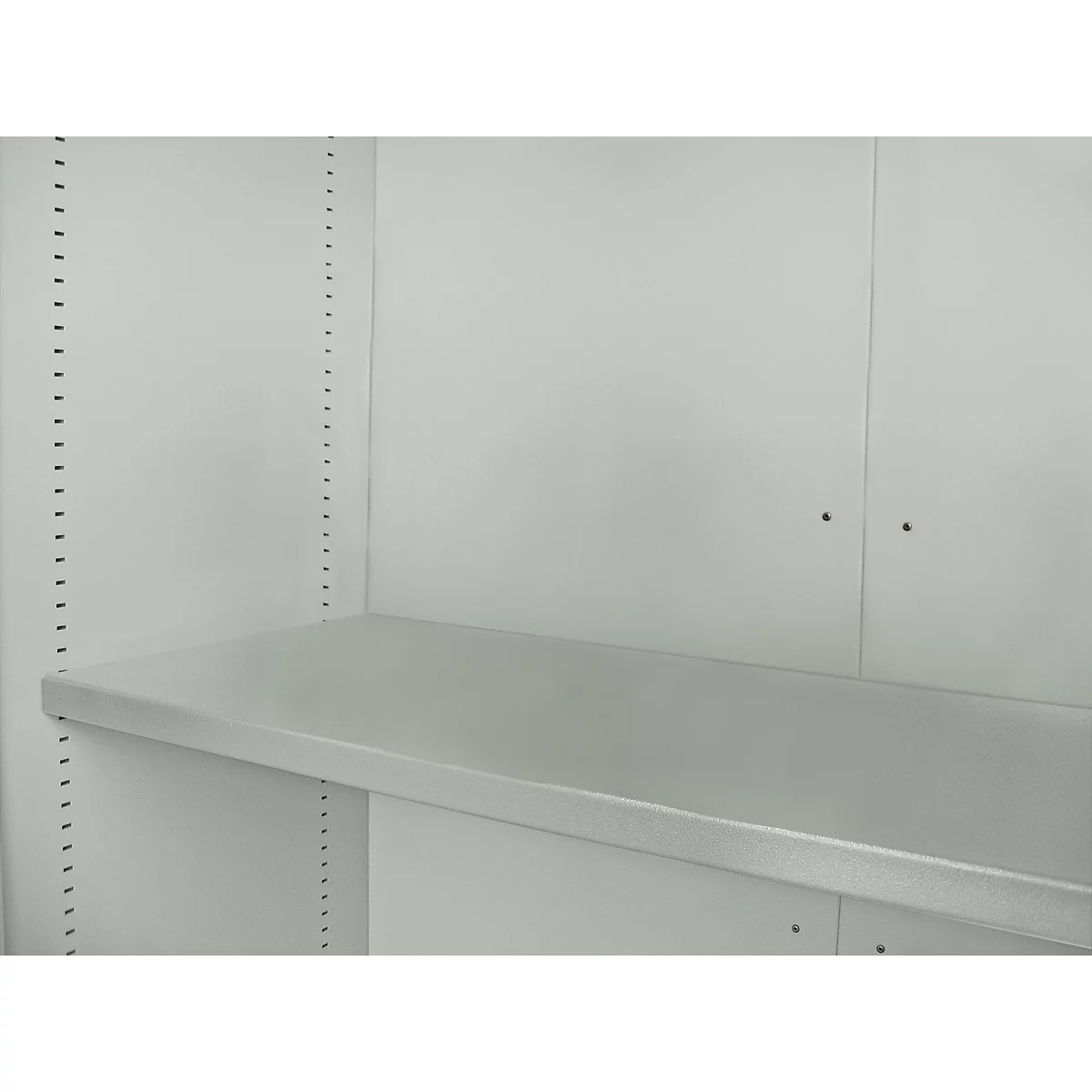 Interior view of a shelf with a light gray shelf installed in a white cabinet. Holes for height adjustment can be seen in the side walls.