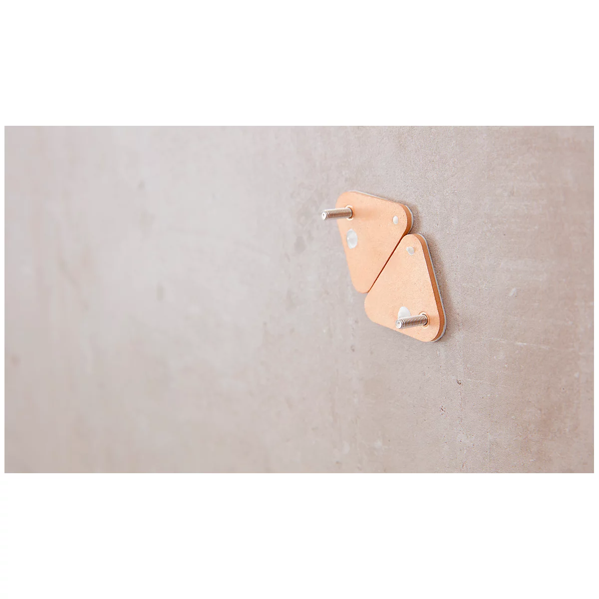 Two triangular, light brown wall hooks on a gray wall. Each hook has a silver metal pin attached.