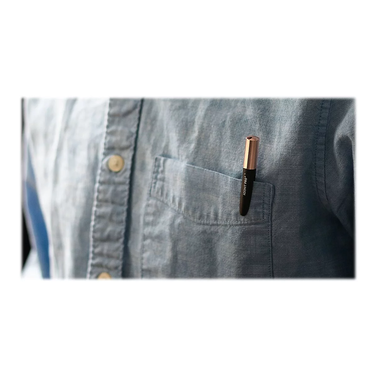 Schwarzer Stift mit goldener Spitze in einer Hemdtasche. Der Stoff ist blau.
