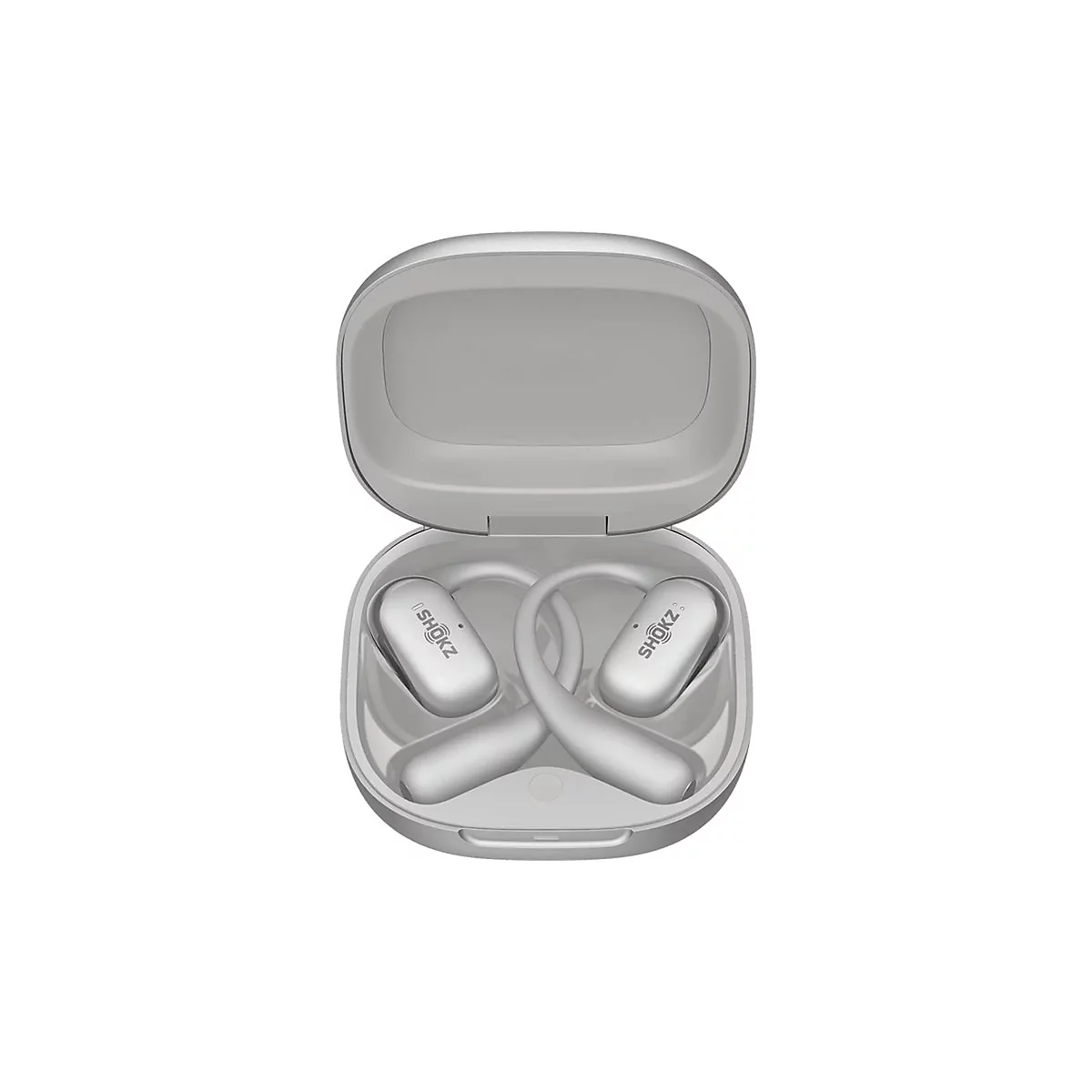Silberne Shokz Open-Ear-Kopfhörer in einem geöffneten Ladecase vor weißem Hintergrund.