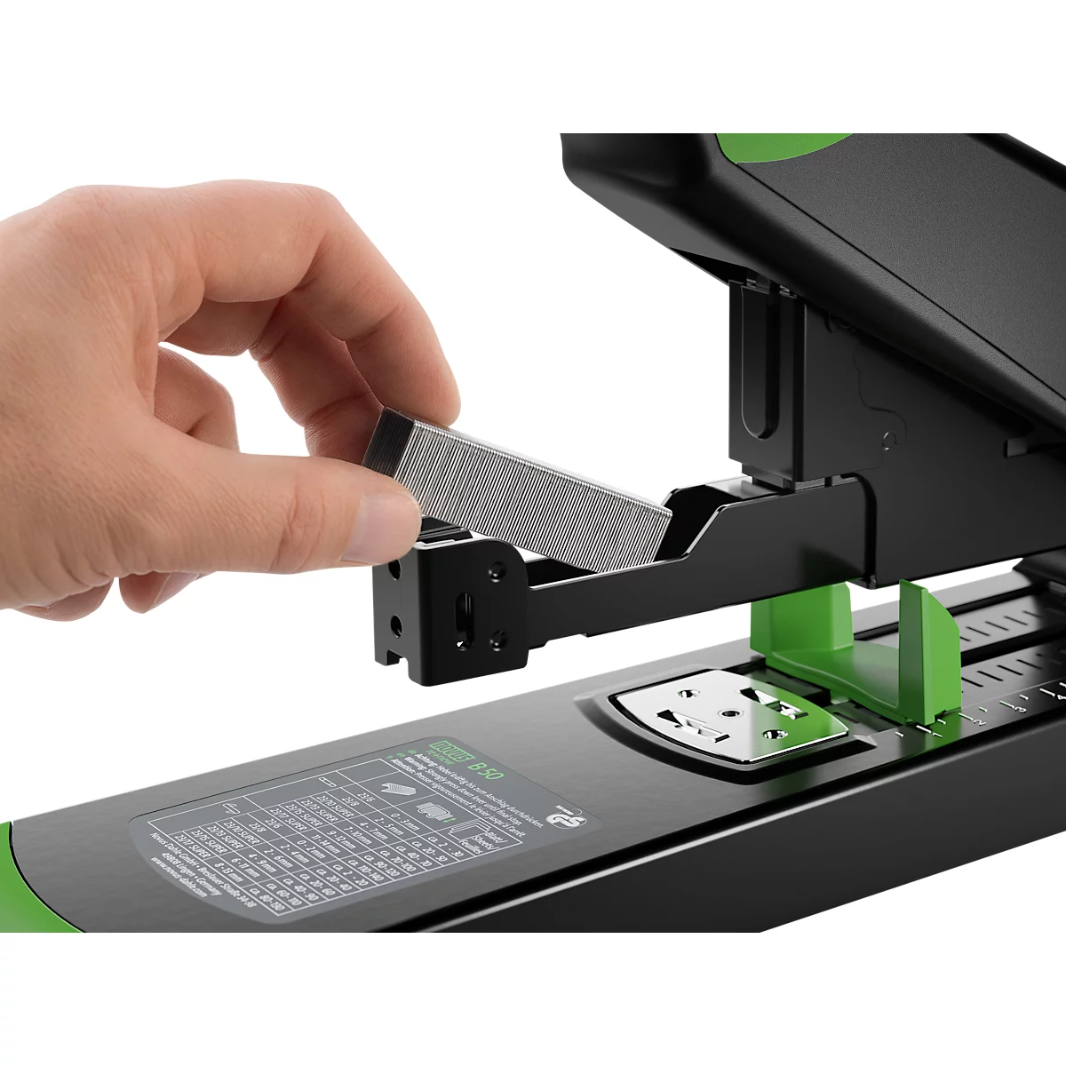 Gros plan d'une main chargeant des agrafes dans une agrafeuse noire et verte.