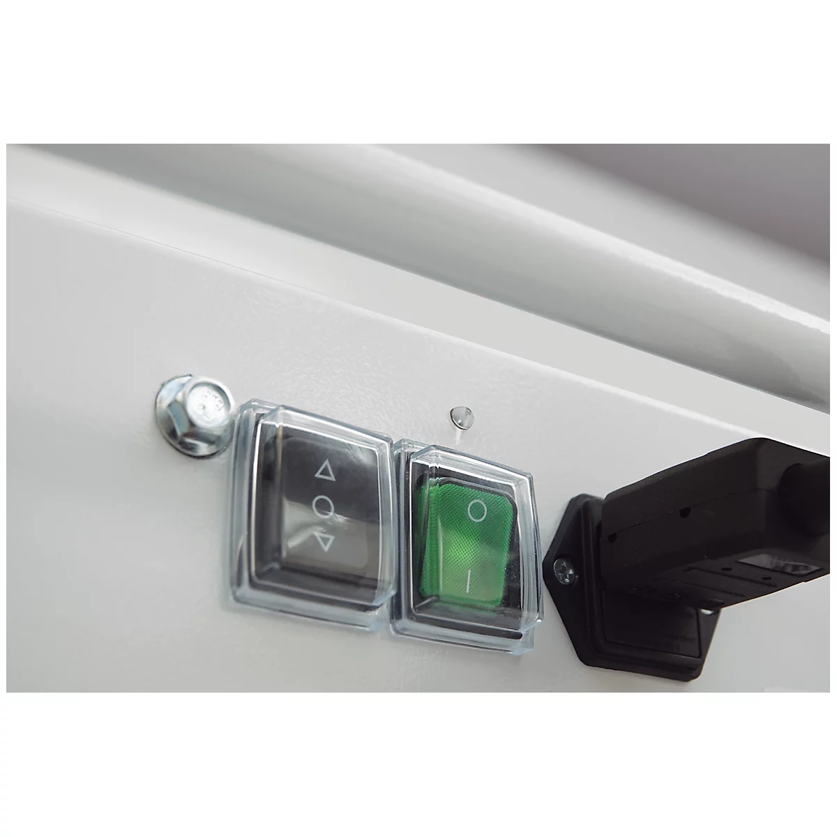 Close-up of two switches, a grey switch with arrow signs and a green switch, plus a black connector.