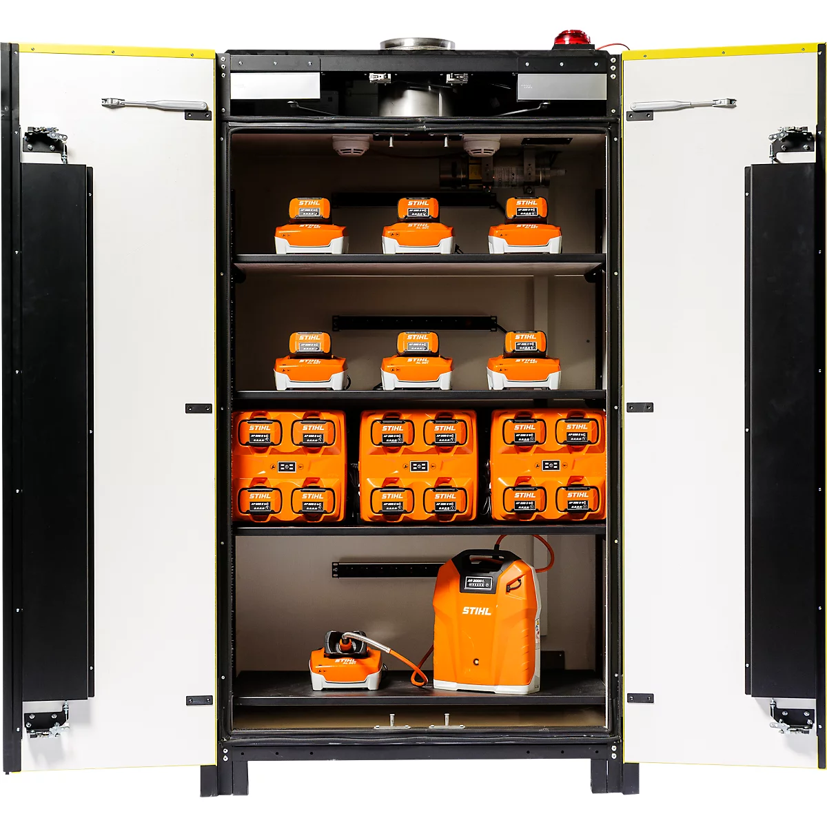Offener Schrank mit Batterieladegeräten und Akkus. Auf den Regalen stehen orangefarbene Batterien und Ladegeräte.