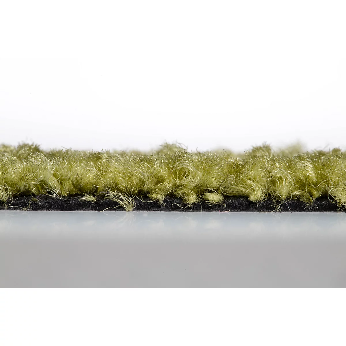 Primer plano de la estructura del borde de una alfombra de pelo largo de color verde oliva con reverso negro.