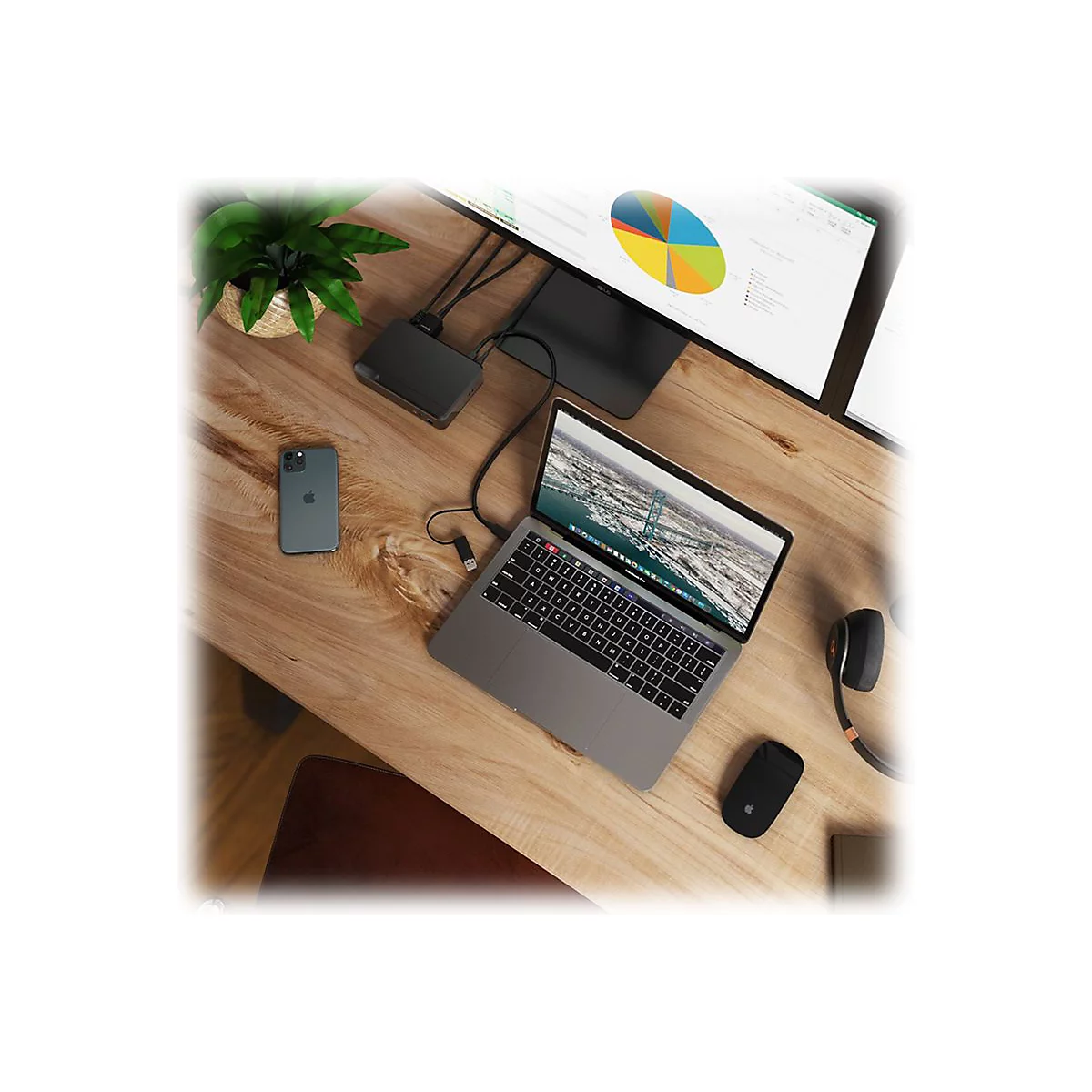 Ansicht von oben eines Schreibtisches mit Laptop, Monitor, Telefon und ZubehÃ¶r. Der Monitor zeigt ein Diagramm, der Laptop eine BrÃ¼cke.