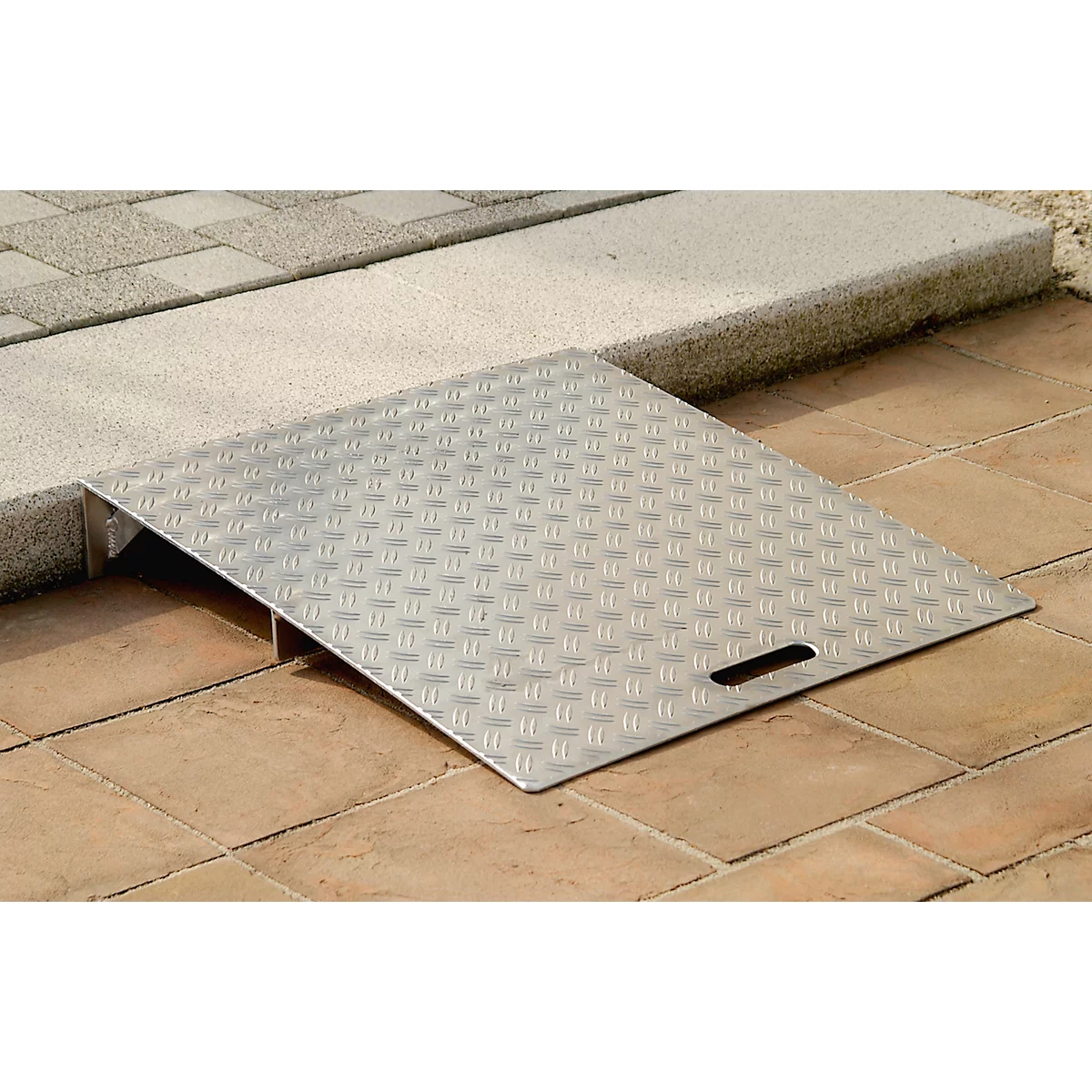 Silver ramp with checkered surface, overcoming a height difference. A handle is recessed.