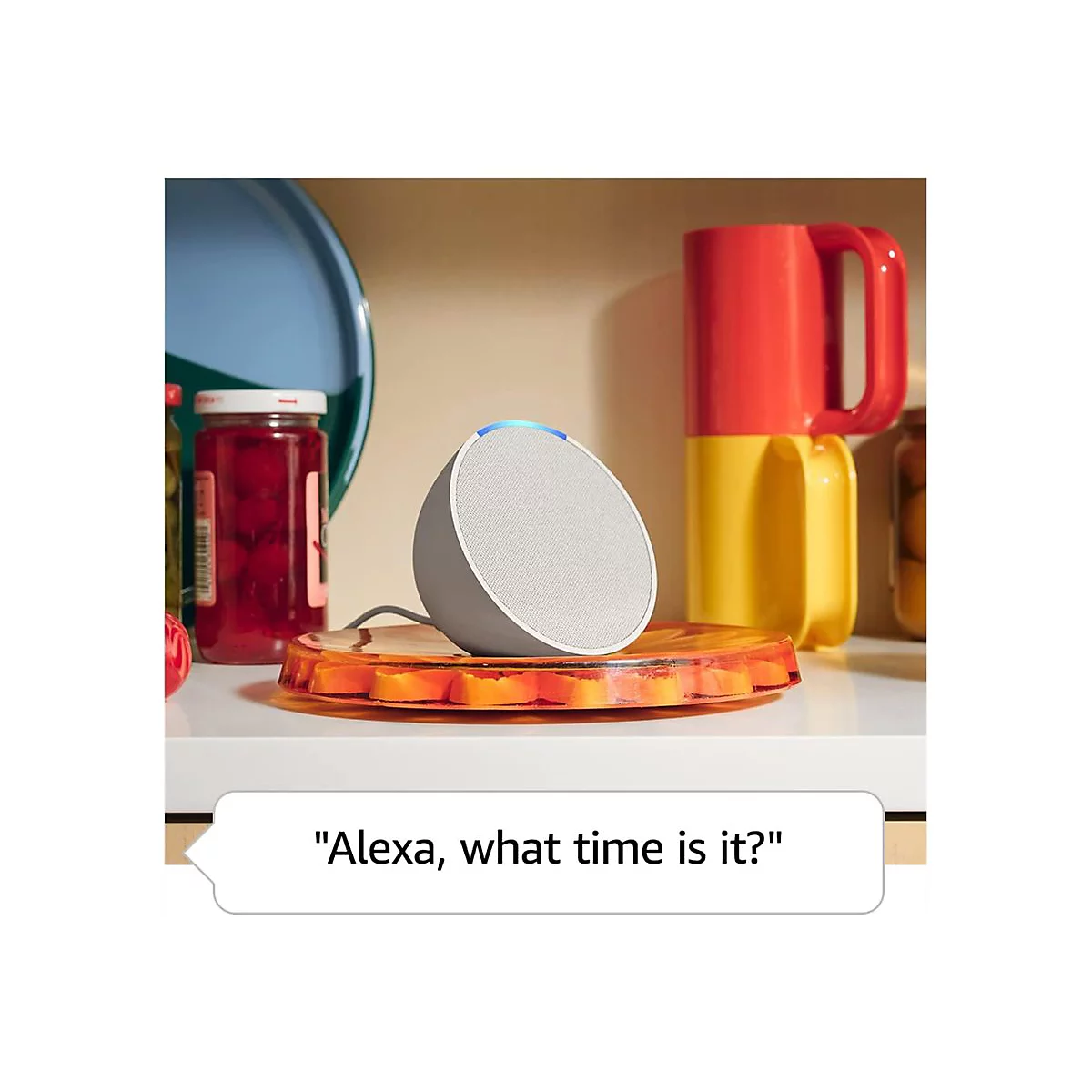 Grauer Smart Speaker auf Teller. Dahinter Regale mit MarmeladenglÃ¤sern und Bechern.