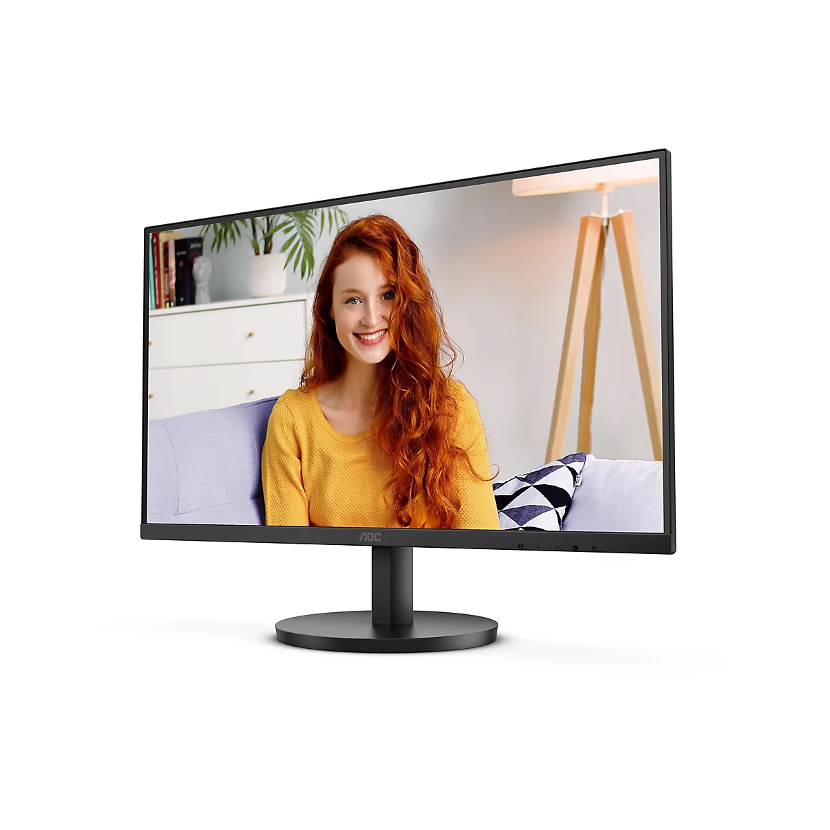 Ein schwarzer AOC-Monitor zeigt eine lächelnde Frau mit roten Haaren, die vor einem Hintergrund sitzt, auf dem sich ein Sofa, eine Stehlampe und eine Kommode befinden.