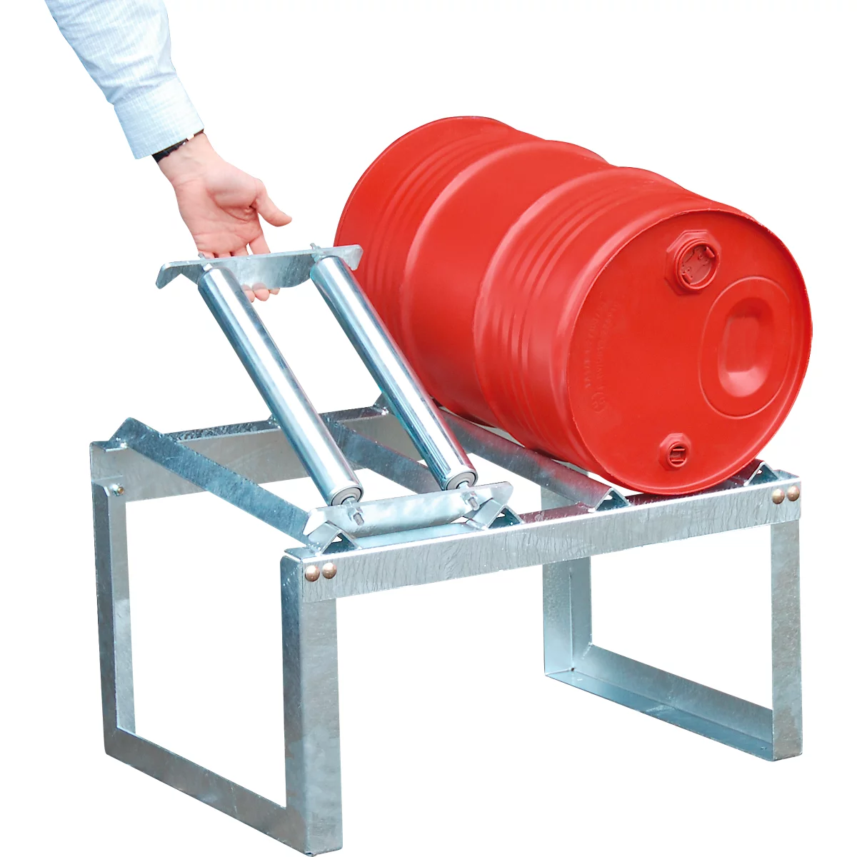 Un barril de aceite rojo descansa sobre una estructura metálica. Una mano toca la construcción.