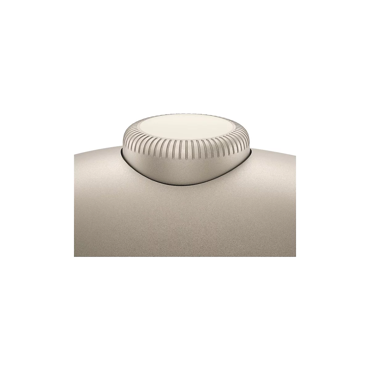Nahaufnahme eines runden, geriffelten Einstellknopfes in hellem Beige auf einer glatten, körnigen Oberfläche.