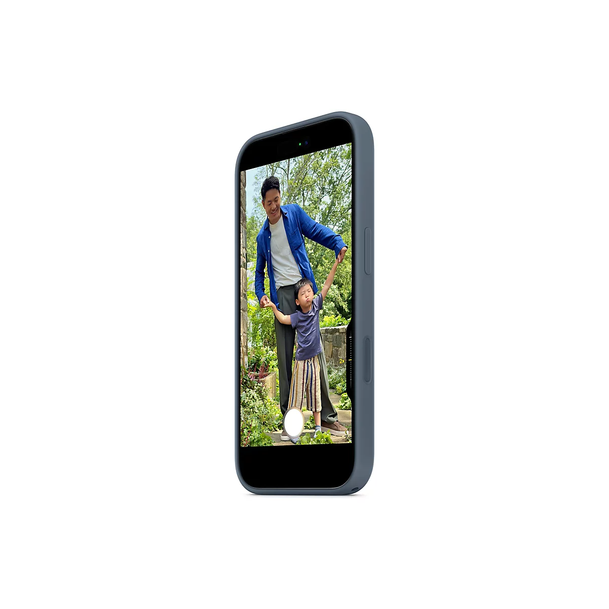 Ein Smartphone zeigt ein Bild eines Vaters, der seinen weinenden Sohn an den Händen hält. Beide stehen in einem Garten.