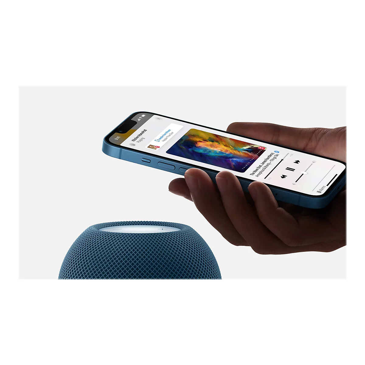 Ein Smartphone zeigt die Musik-App mit einem Song, der gerade auf einem HomePod-Lautsprecher abgespielt wird. Der Lautsprecher ist unten links im Bild zu sehen.