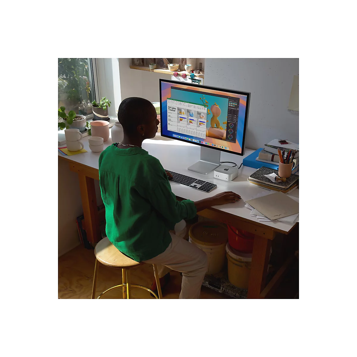Person sitzt vor einem Computer. Sie trÃ¤gt ein grÃ¼nes Hemd und tippt auf einer Tastatur.