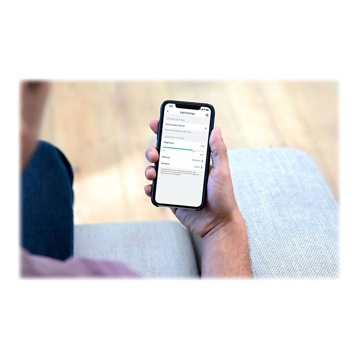 Hand hält Smartphone mit geöffneter App zur Einstellung von Lichtintensität und Sensoren.