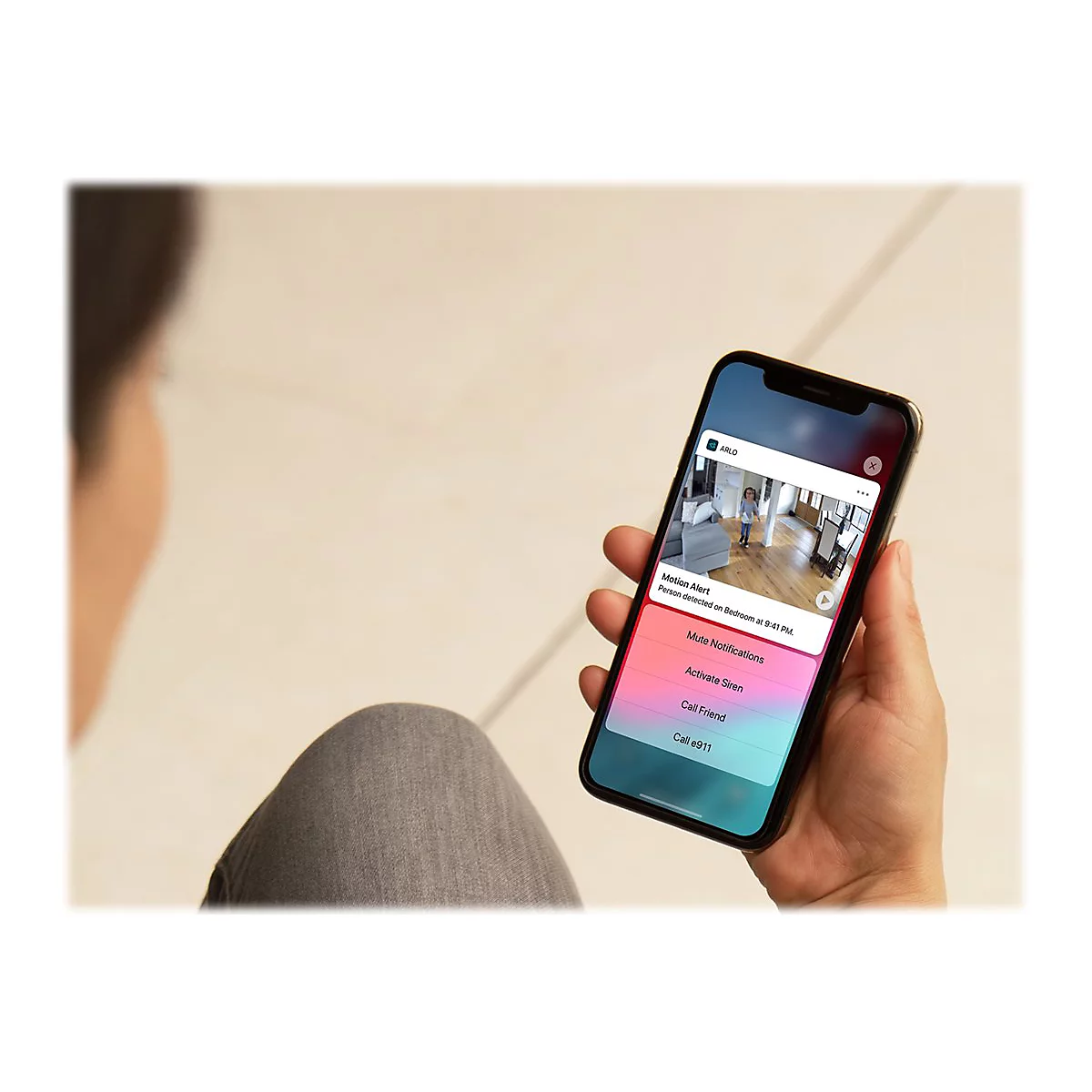 Nahaufnahme eines Smartphones mit Benachrichtigung einer Überwachungskamera. Eine Hand hält das Telefon. Verschiedene Optionen zur Auswahl.