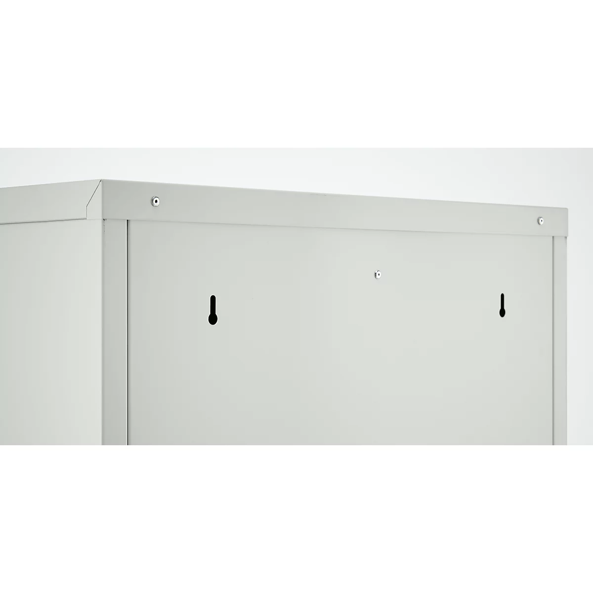Toma detallada de una pared de metal gris. Se ven ganchos, tornillos y bordes.