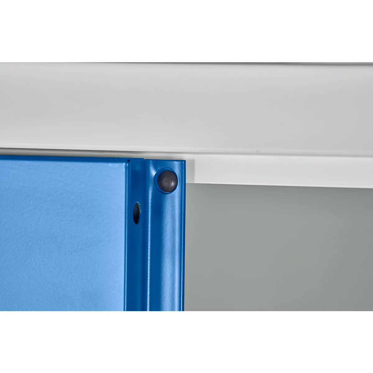 Gros plan sur un support d'étagère en métal bleu avec un tampon en caoutchouc gris devant une poutre gris clair.