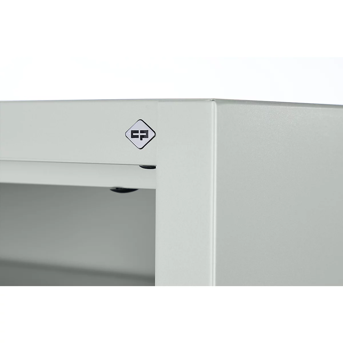 Détail d'un bord métallique gris clair avec le logo 'CP'.