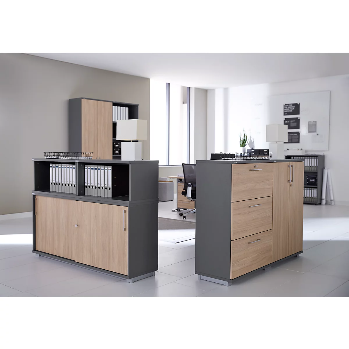 Vue de bureau avec deux armoires avec façades en bois et corps gris. Des chemises et des fournitures de bureau sont visibles.