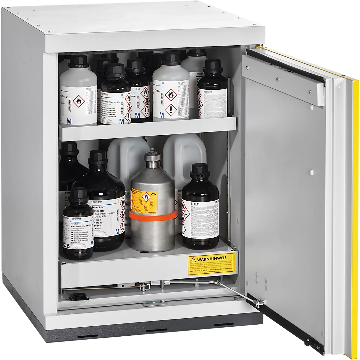 Armoire ouverte avec des bouteilles de produits chimiques, dont des étiquettes de substances dangereuses. Panneaux d'avertissement jaunes. La porte est partiellement ouverte.