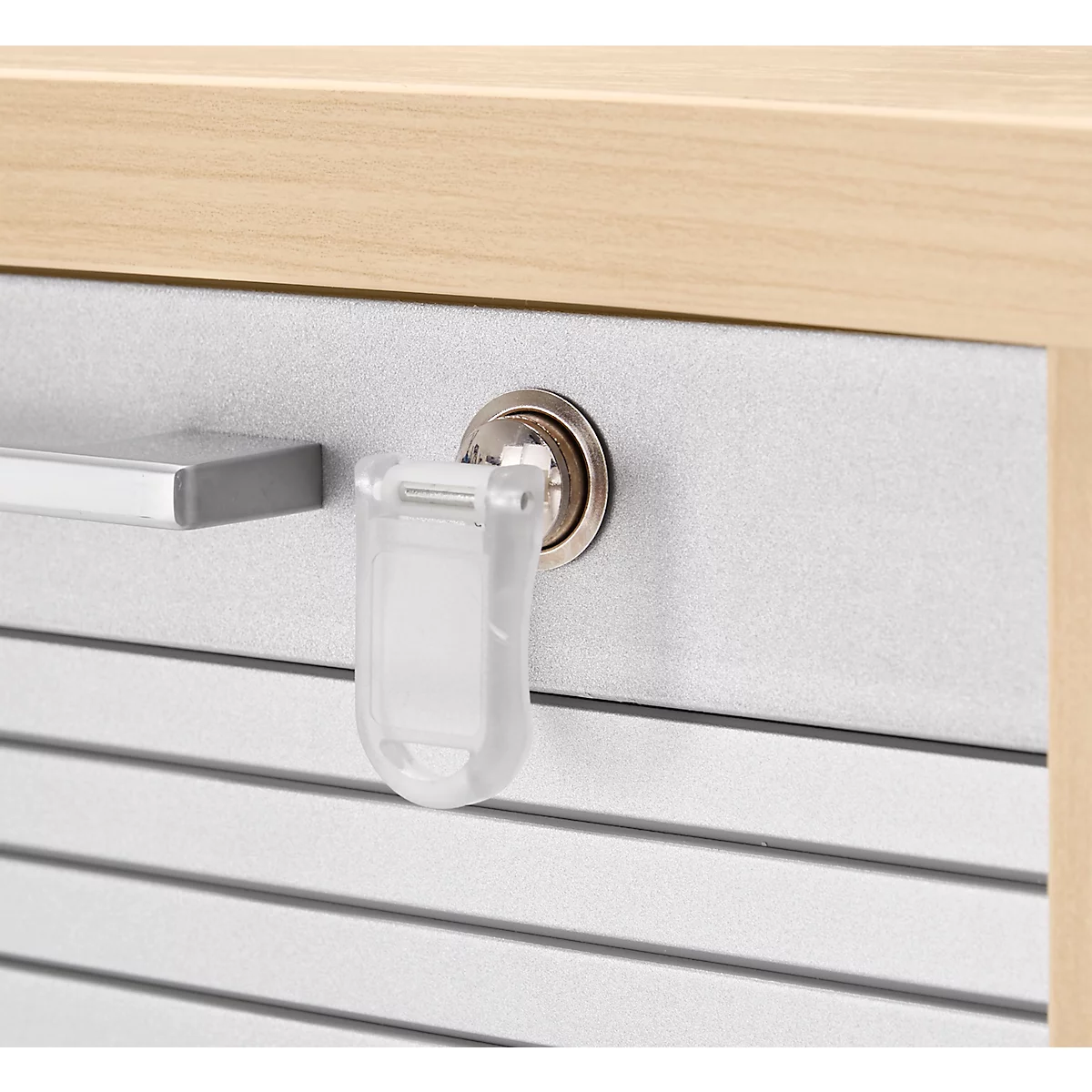 Gros plan de la clé et de la poignée d'une porte de placard. La clé est en métal et se trouve dans la serrure.