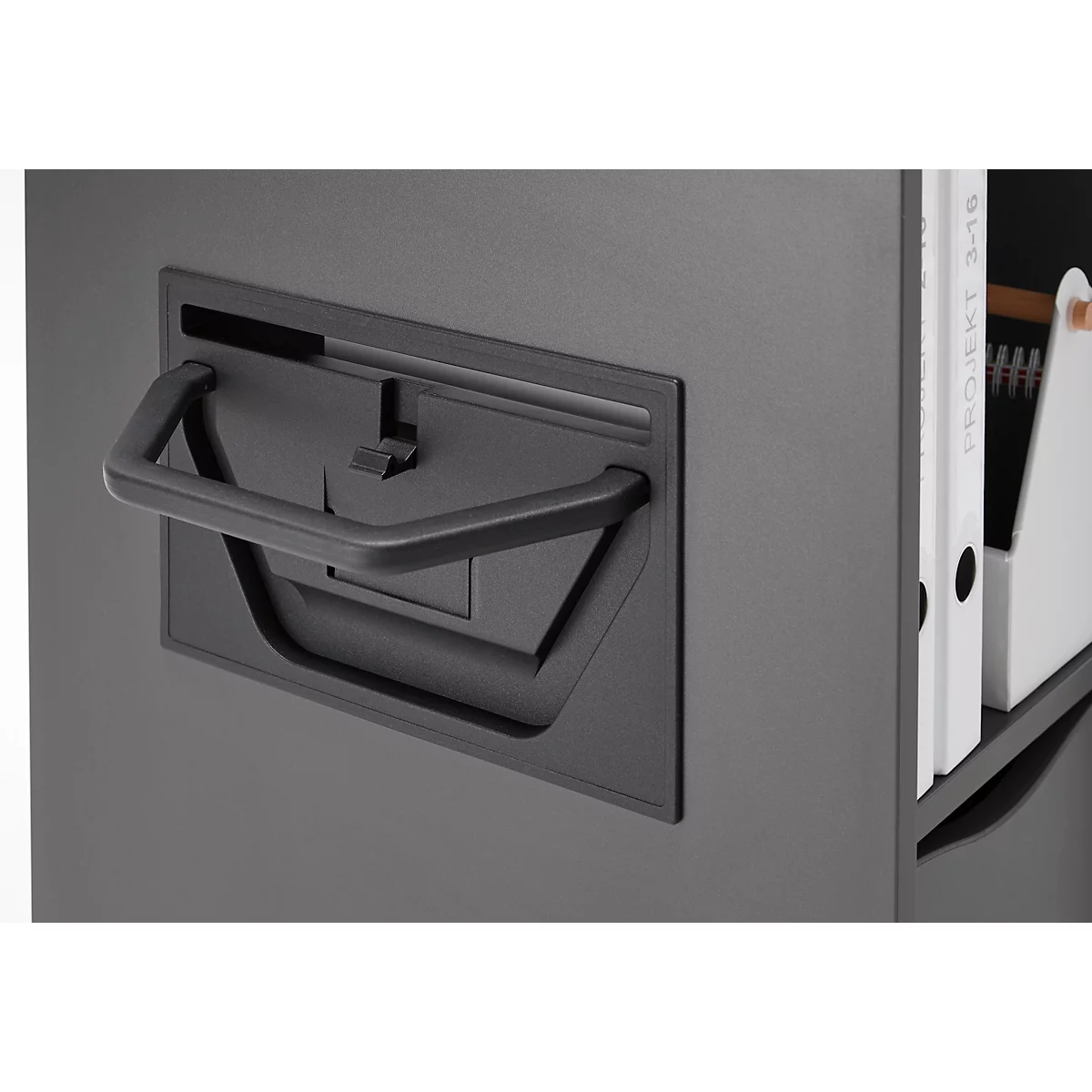 Gros plan d'une armoire noire. Poignée tirée, à côté des classeurs blancs.