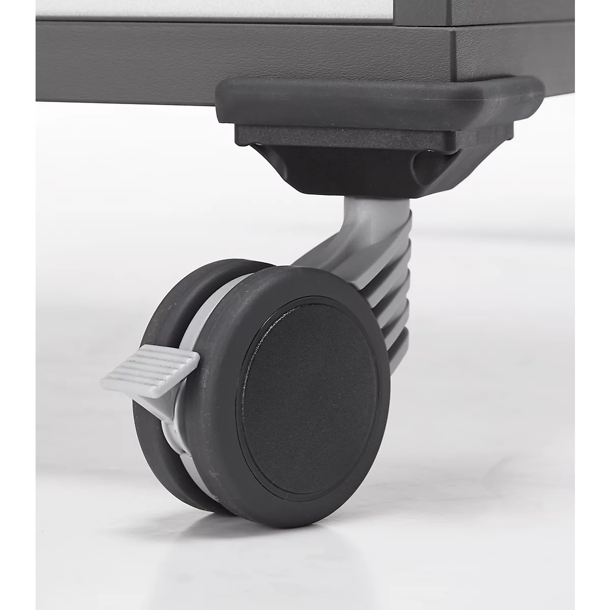 Gros plan d'une roulette de meuble noire avec frein de stationnement.