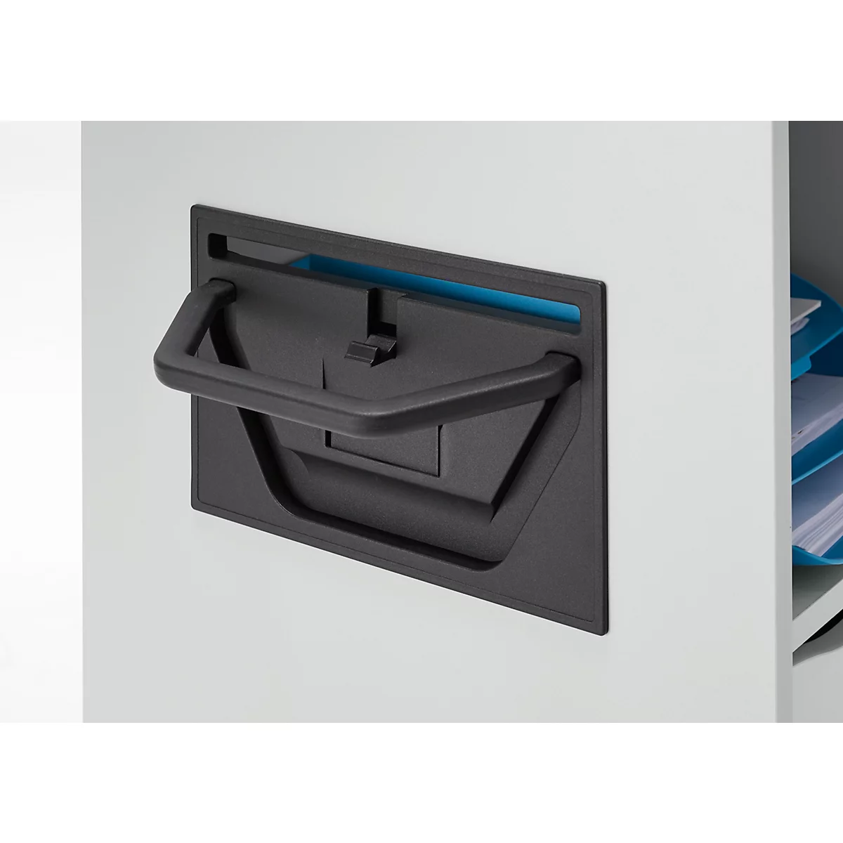 Gros plan d'une poignée de placard noire avec prise et fond bleu. Un compartiment ouvert avec des documents est visible en arrière-plan.