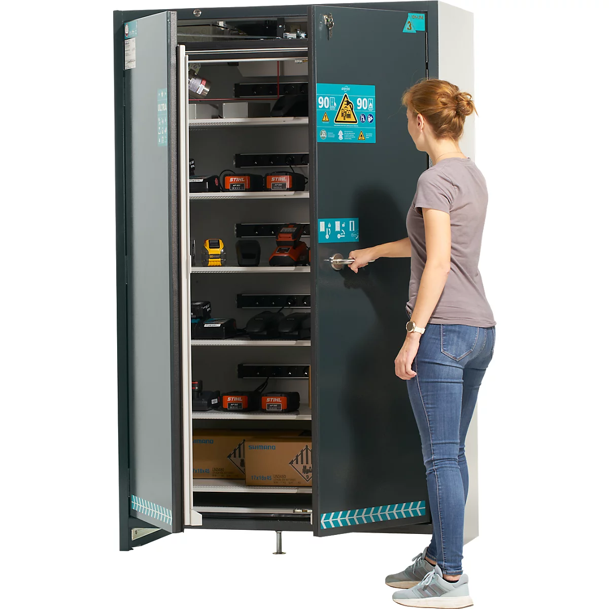 Eine Frau öffnet einen Schrank, in dem Werkzeuge und Geräte aufbewahrt werden.