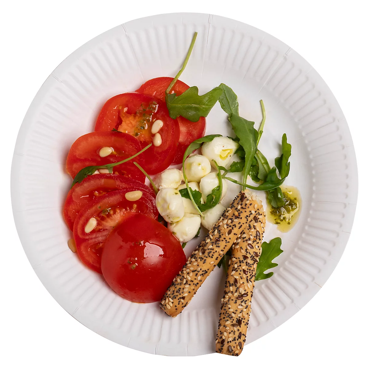 Salade de tomates et mozzarella sur une assiette blanche, avec des gressins.
