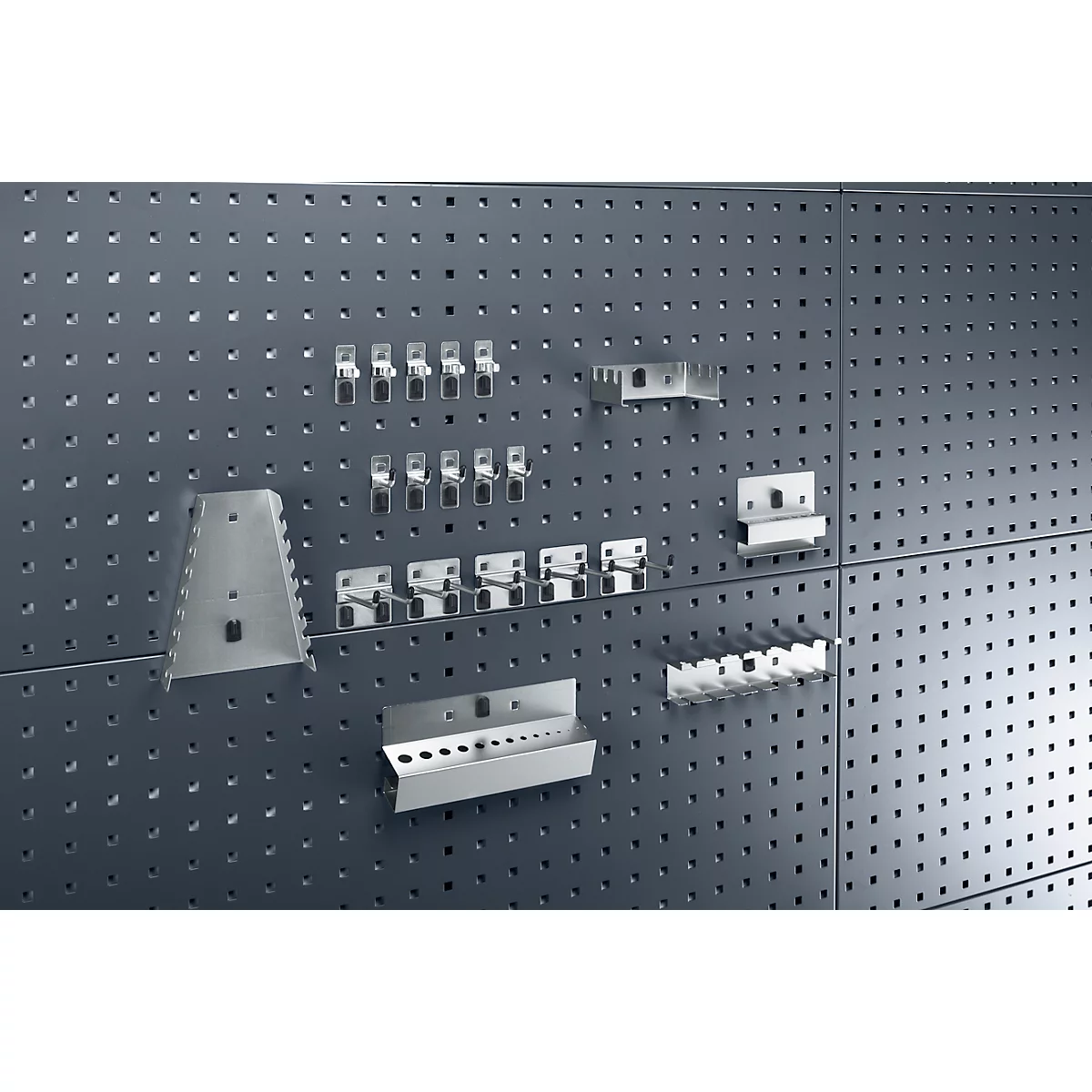 Grijze pegboard met metalen gereedschapshouders.