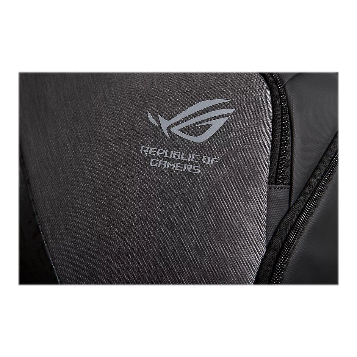 Nahaufnahme des ROG Republic of Gamers Logos auf einer dunkelgrauen Rucksackoberfläche mit Textilstruktur.