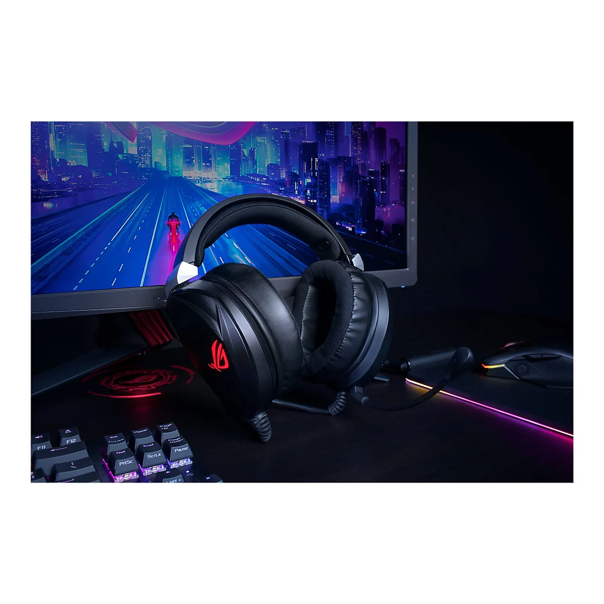 Schwarzes Gaming-Headset auf Tisch. Im Hintergrund Bildschirm mit futuristischer Stadt. Tastatur, Maus erkennbar.