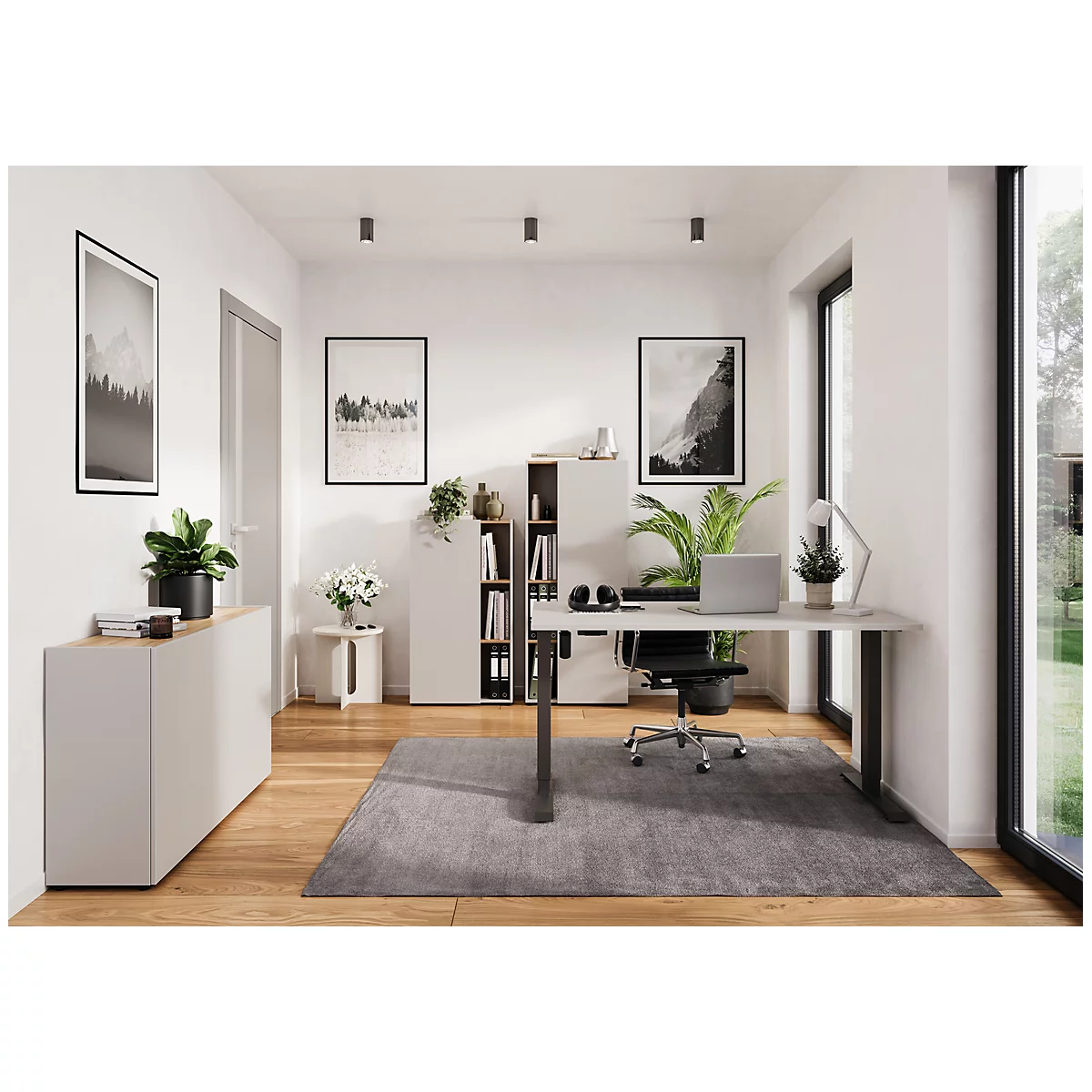 Een modern thuiskantoor met bureau, laptop, planten en schilderijen.