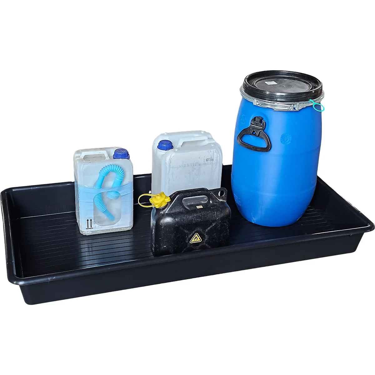 Schwarze Wanne mit Kanistern und Fass. Blaue und weiße Kanister, schwarzer Kanister mit gelbem Deckel und gelbem Dreieck. Blaues Fass.