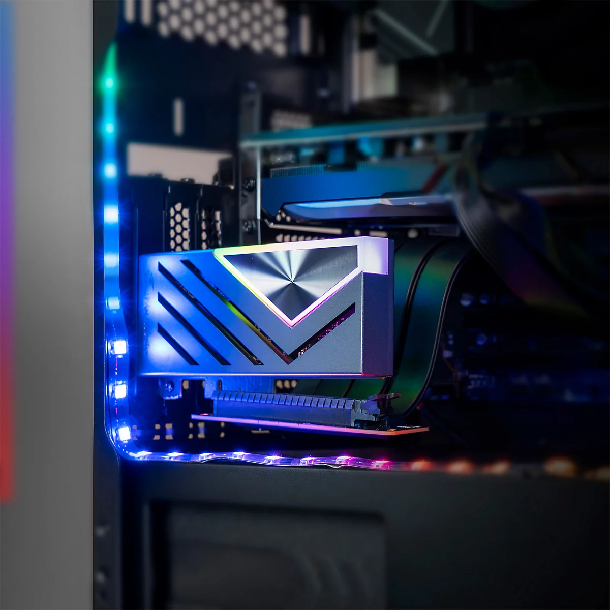 Gaming-PC-Innenraum mit einer beleuchteten M.2-SSD im Vordergrund und blauem LED-Lichtstreifen an der Gehäuseseite.