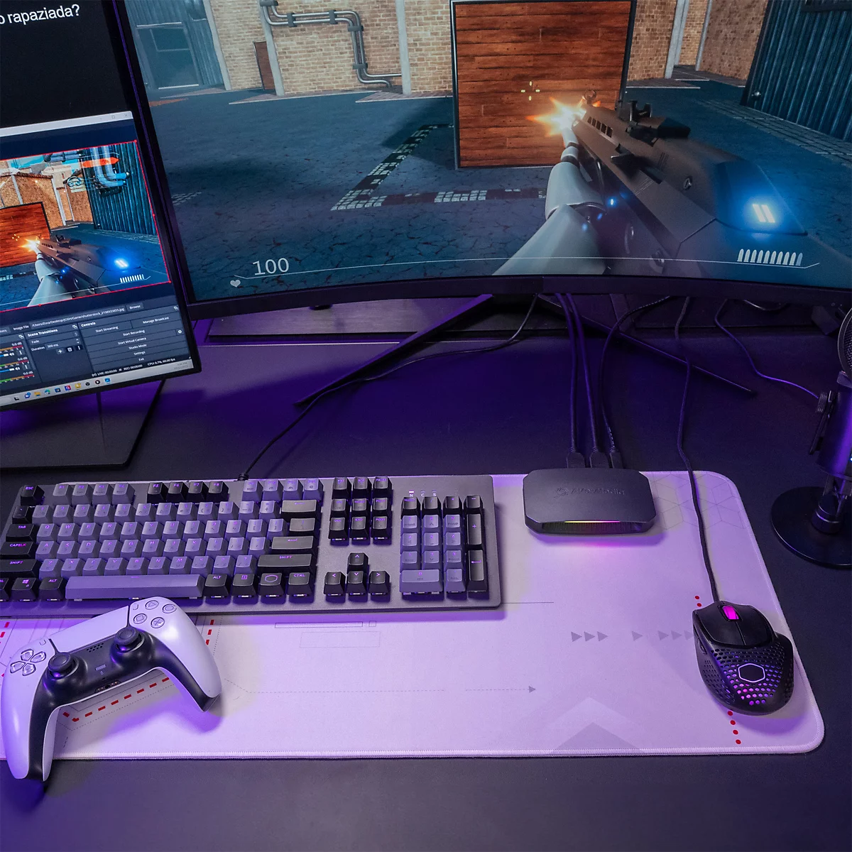 Gaming-Setup mit gebogenem Monitor, Tastatur, Controller und AVerMedia Capture Card auf hellem Mauspad.