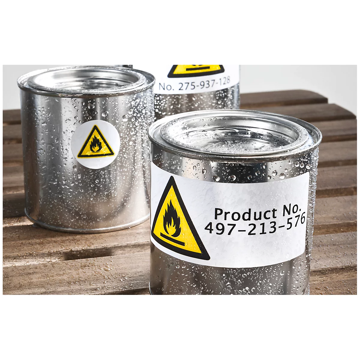 Three metal containers with labels showing a flame symbol. One says "Product No. 497-213-576".