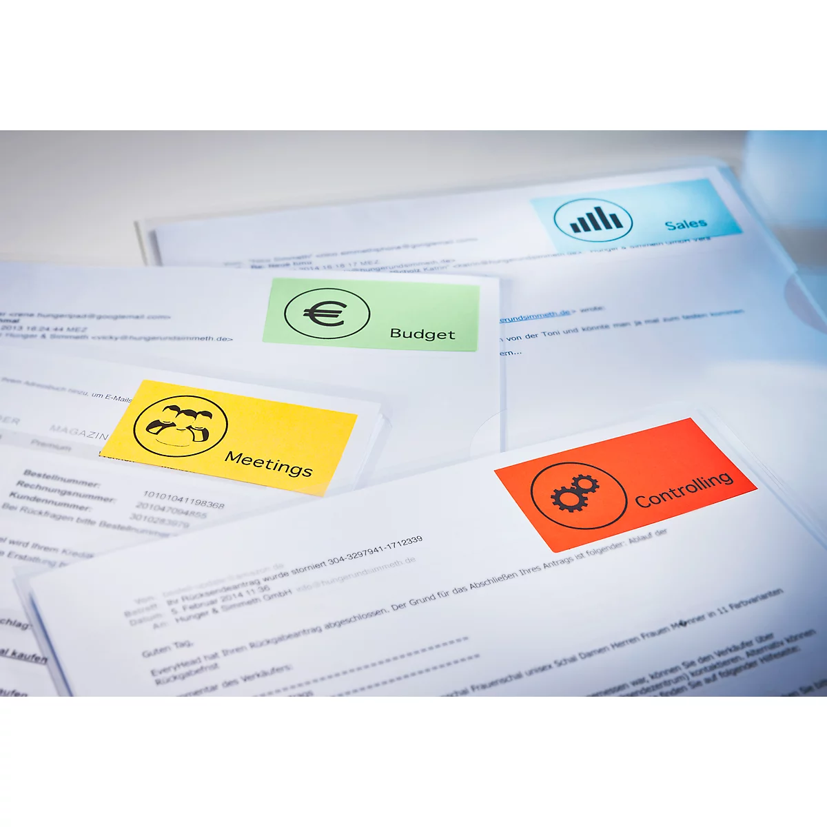 Close-up of documents with colorful sticky notes. Notes label: Budget, Meetings, Controlling, and Sales.