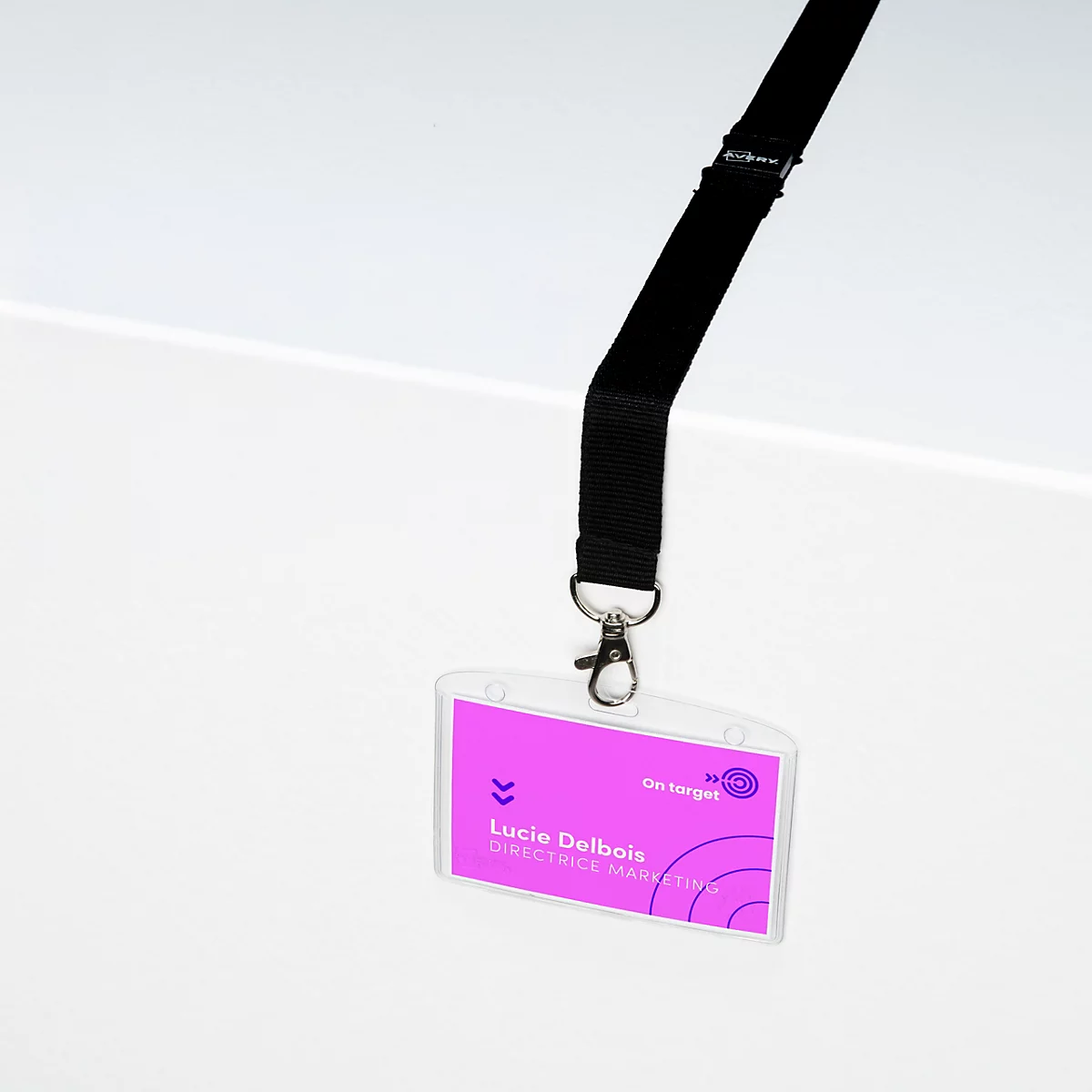 Schwarzes Lanyard mit Namensschildtasche und pinkfarbenem Namensschild vor weißem Hintergrund.