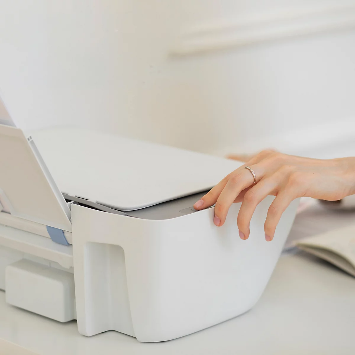 Hand bedient een witte laserprinter; tekst: printercompatibiliteit voor laserprinters.
