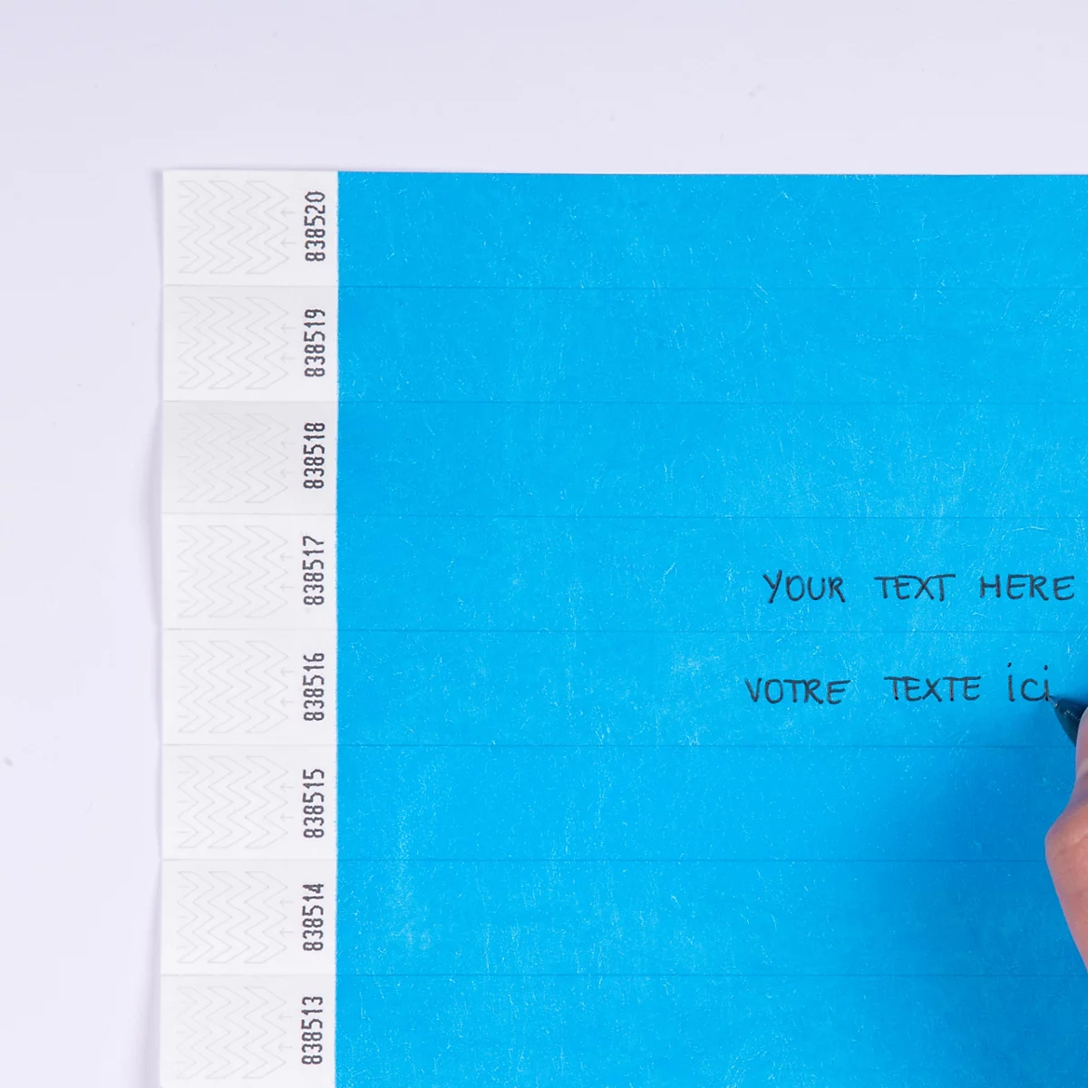 Lichtblauwe polsband wordt beschreven met een pen, met de tekst 'Beschriftbar mit Permanent-Marker'.