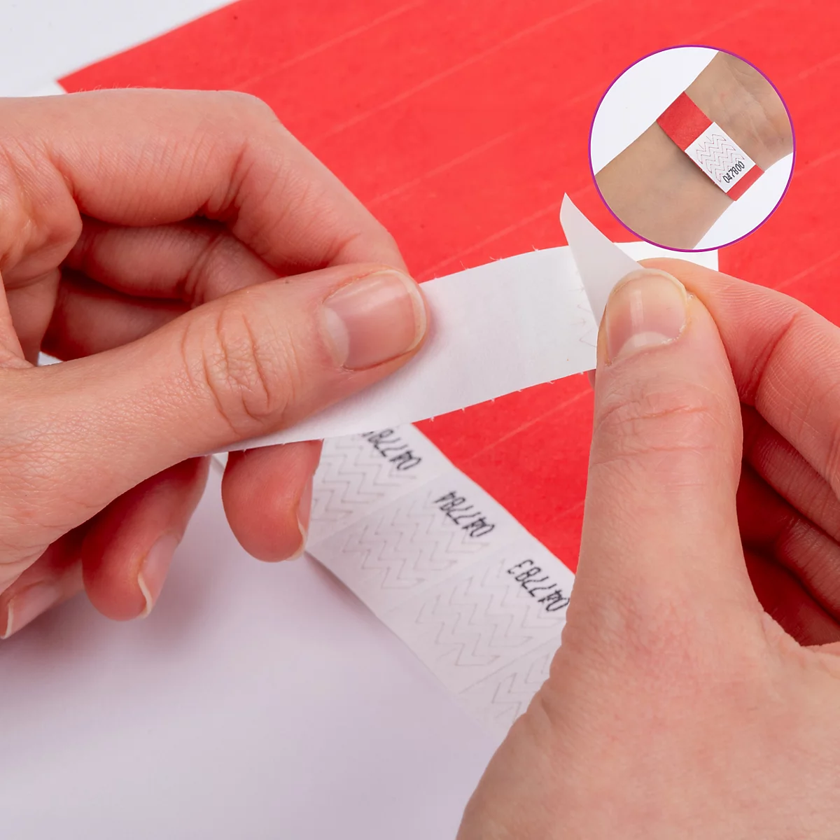 Handen trekken een rood polsbandje van een vel. Een cirkel toont het bandje om een pols. Tekst: Manipulatiebestendig.
