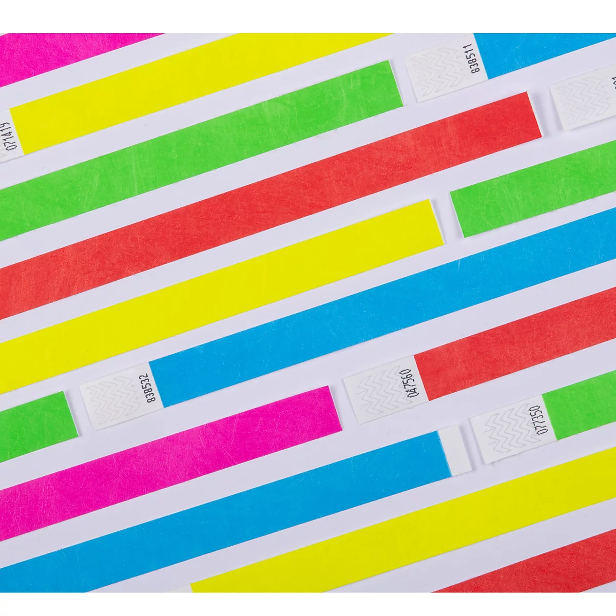 Meerdere neonkleurige polsbandjes met opeenvolgende nummering liggen op een lichte achtergrond.